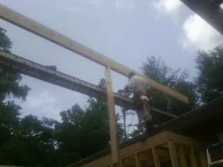 Carpenter setting a ridge beam over a new addition frame — Ice Dam Removal by Roofing Brothers in Columbus City