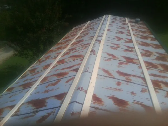 Rusted metal roof panels with new wood purlins before replacement — Storm Damage Roof Repair in Columbus City by Roofing Brothers