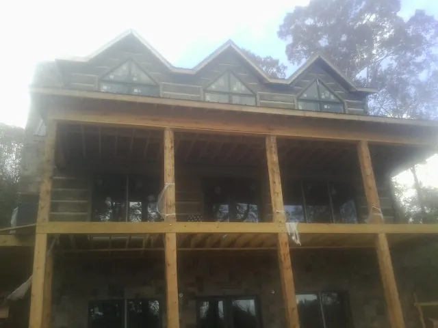 Dormers and porch framing on a large log home under construction — Roof Coating work by our crew in Columbus City