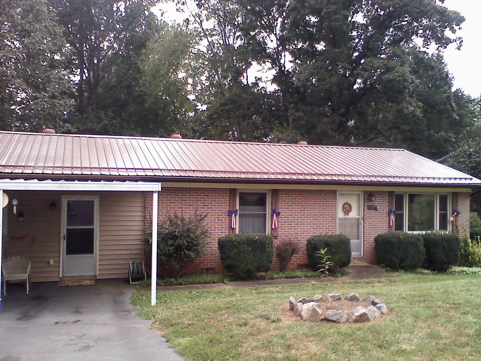 Bronze metal roof and carport on a brick ranch home — Roof Repair work by our crew in Columbus City